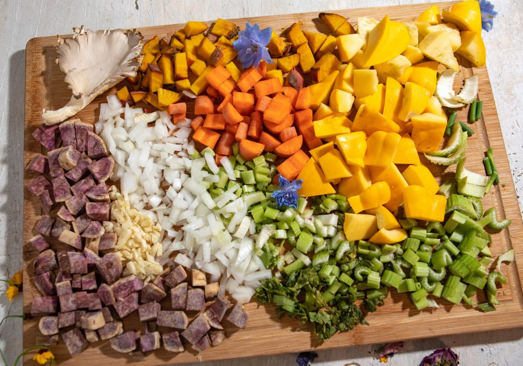 A cutting board filled with brightly colored chopped vegetables 