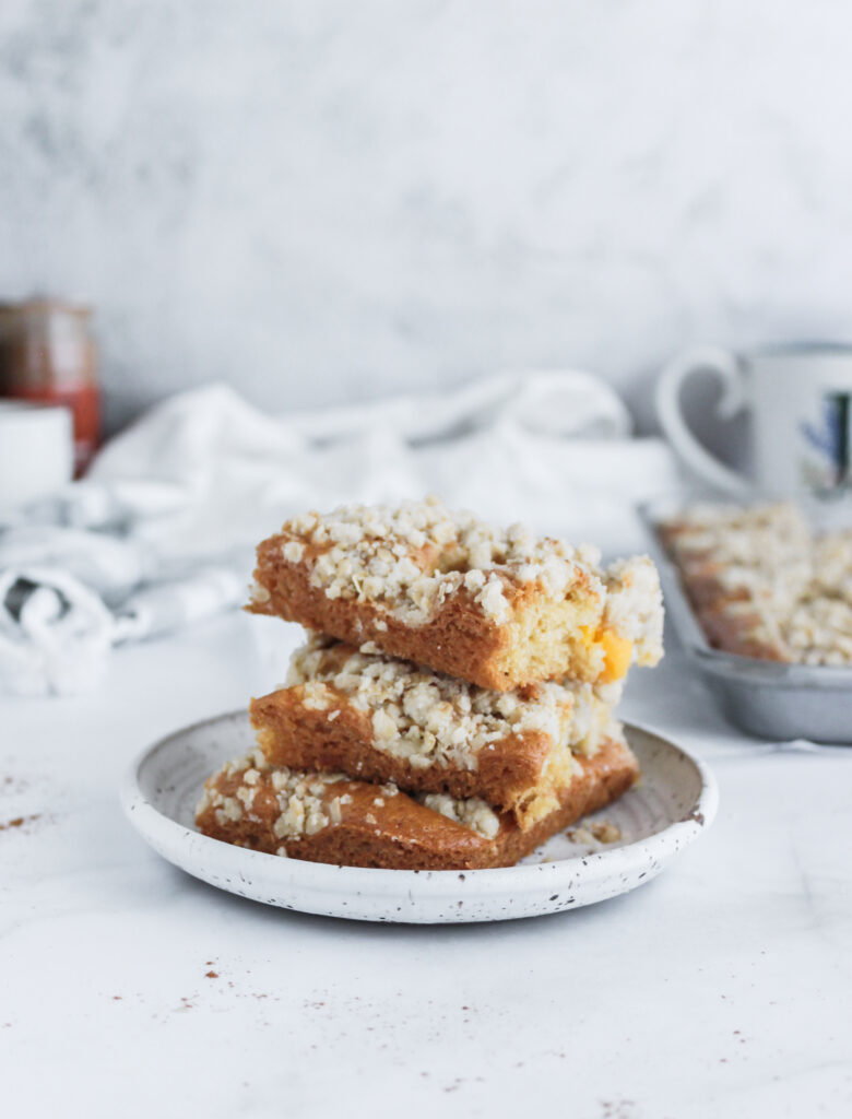 Stacked pieces of peach streusel coffee cake