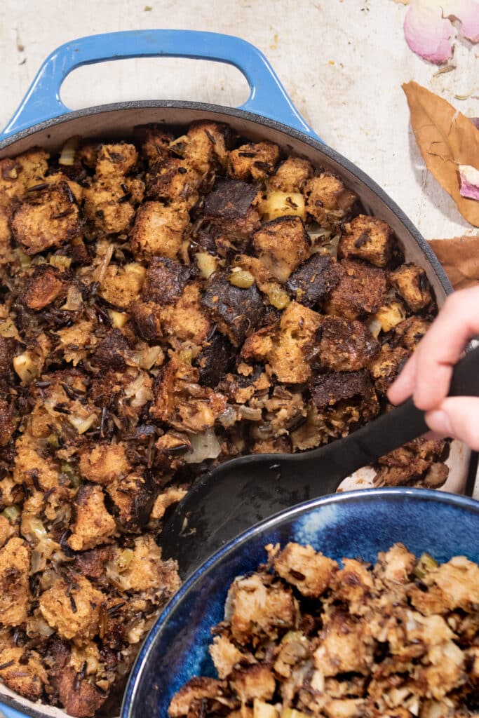 Wild rice apple dressing being served in a casserole dish