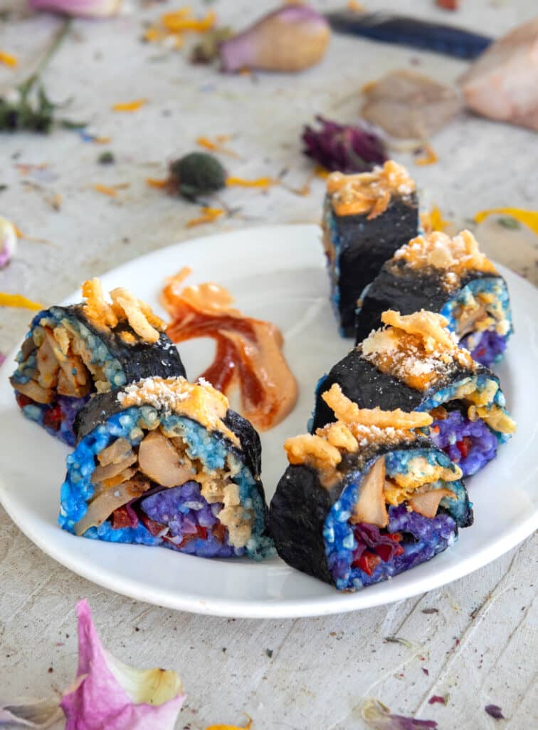 Vegan Sriracha lobster mushroom sushi roll on a plate with sriracha mayo