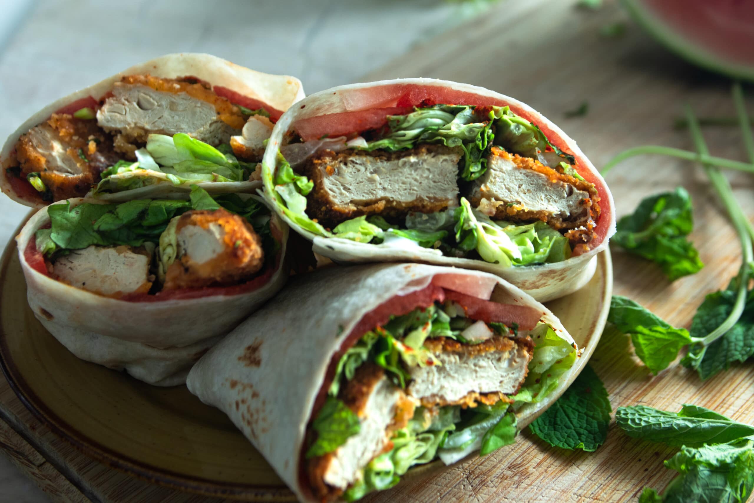 Stacked cut wraps filled with lettuce, seitan, watermelon, and seasonings