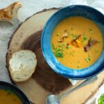 a bowl of lobster mushroom bisque with a sauted lobster mushroom as a garnish