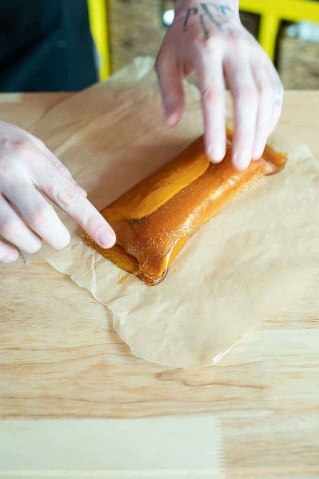 Pinching the ends of the caramel peanut butter log