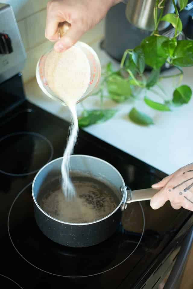 Sugar being poured in a saucepan