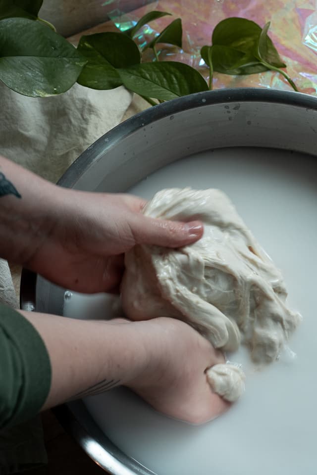 a person holding dough in water