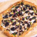 A pizza with morel mushrooms on parchiment paper