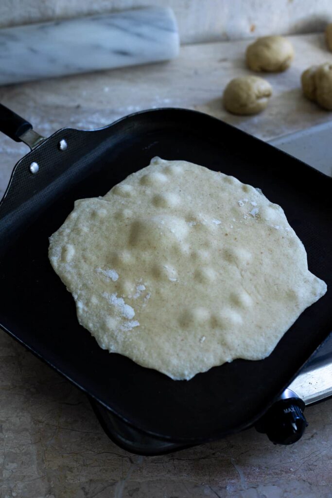 a tortilla bubbling on a frying pan