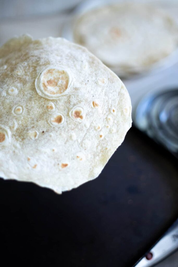 Removing a cooked tortilla from a frying pan