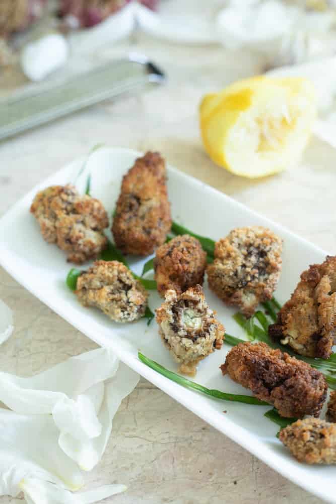 Fried and stuffed morel mushrooms on a white plate