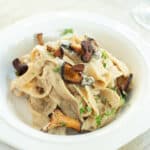 a plate of creamy pasta with chanterelle mushrooms