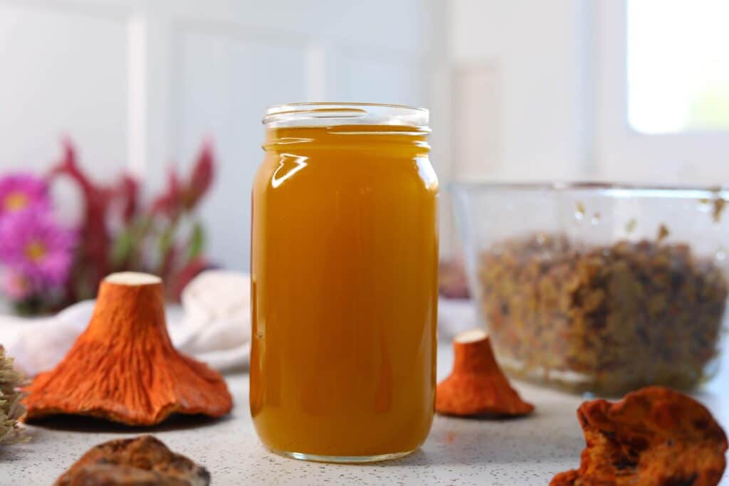 a jar of lobster mushroom oil next to a lobster mushroom