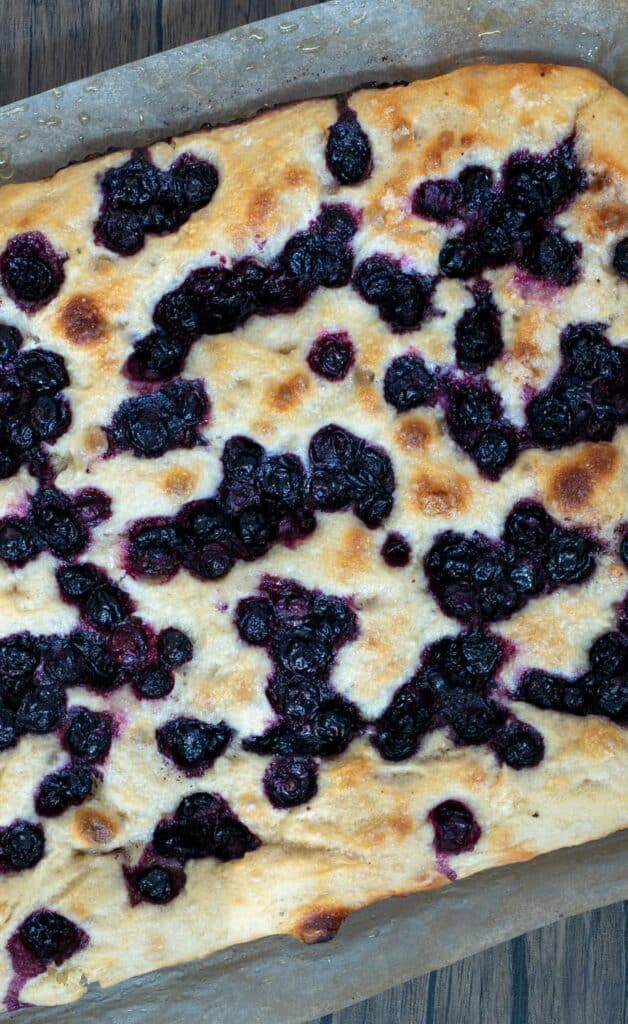 a loaf of blueberry sourdough focaccia on a piece of parchment paper