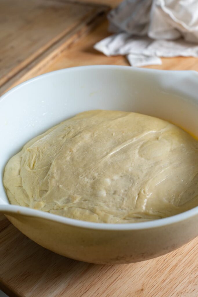 a bowl of pizza dough on a wooden table