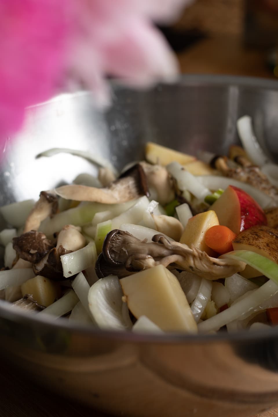 a bowl of mushrooms, vegetables, and chopped apples