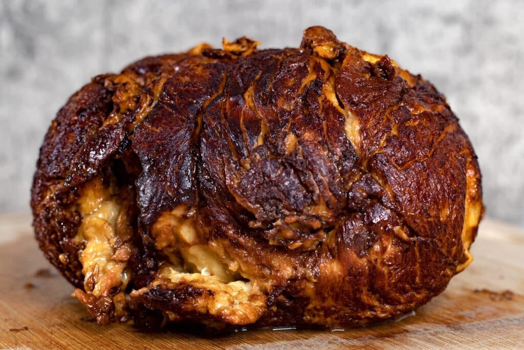 A juicy hunk of seitan on a wooden cutting board.