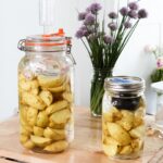 two jars of potatoes fermenting on a wooden table