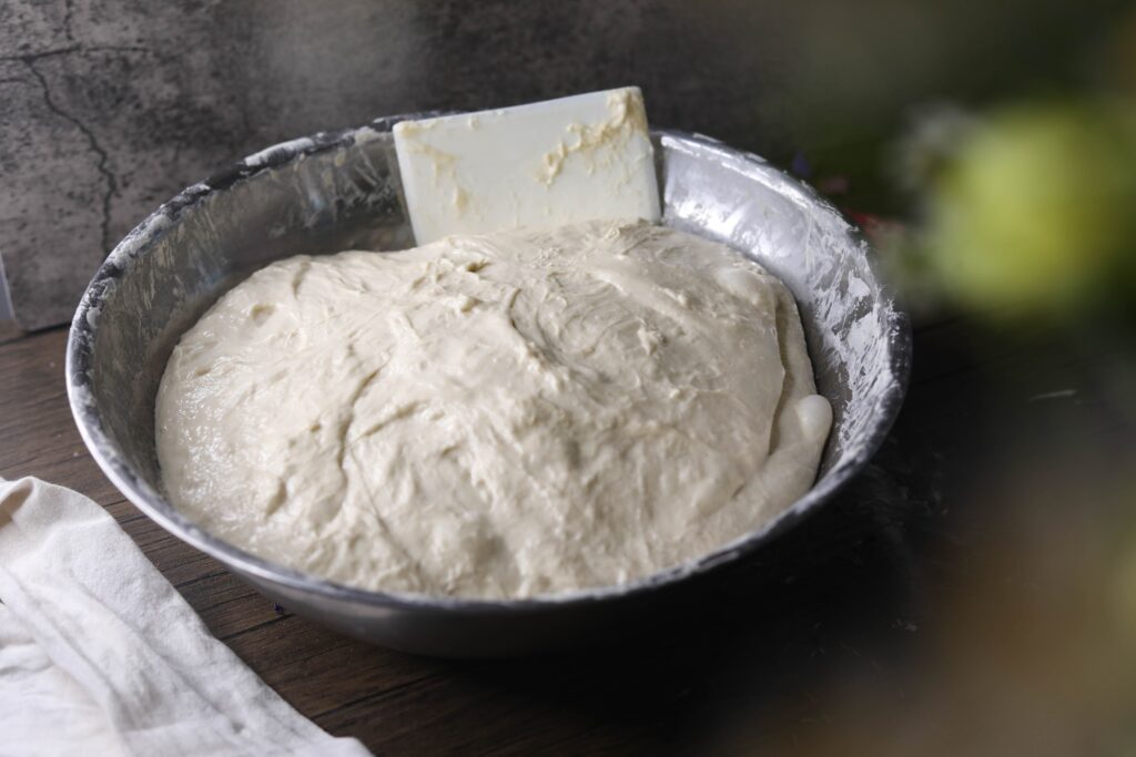 a ball of dough in a silver bowl