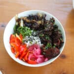a bowl of seitan beef over rice with vegetables