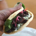 a person holding a seitan beef gyro